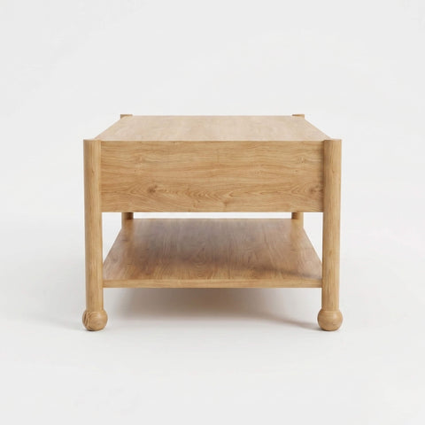 Side profile of Arlo natural oak coffee table showing open lower shelf and classic bun feet
