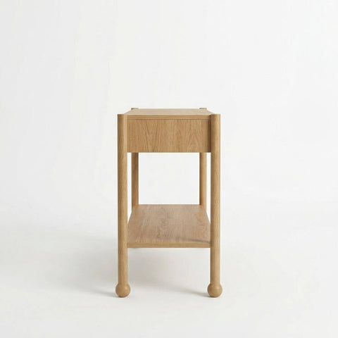 Side profile of Arlo natural oak console table showing depth, lower shelf, and solid wood bun feet