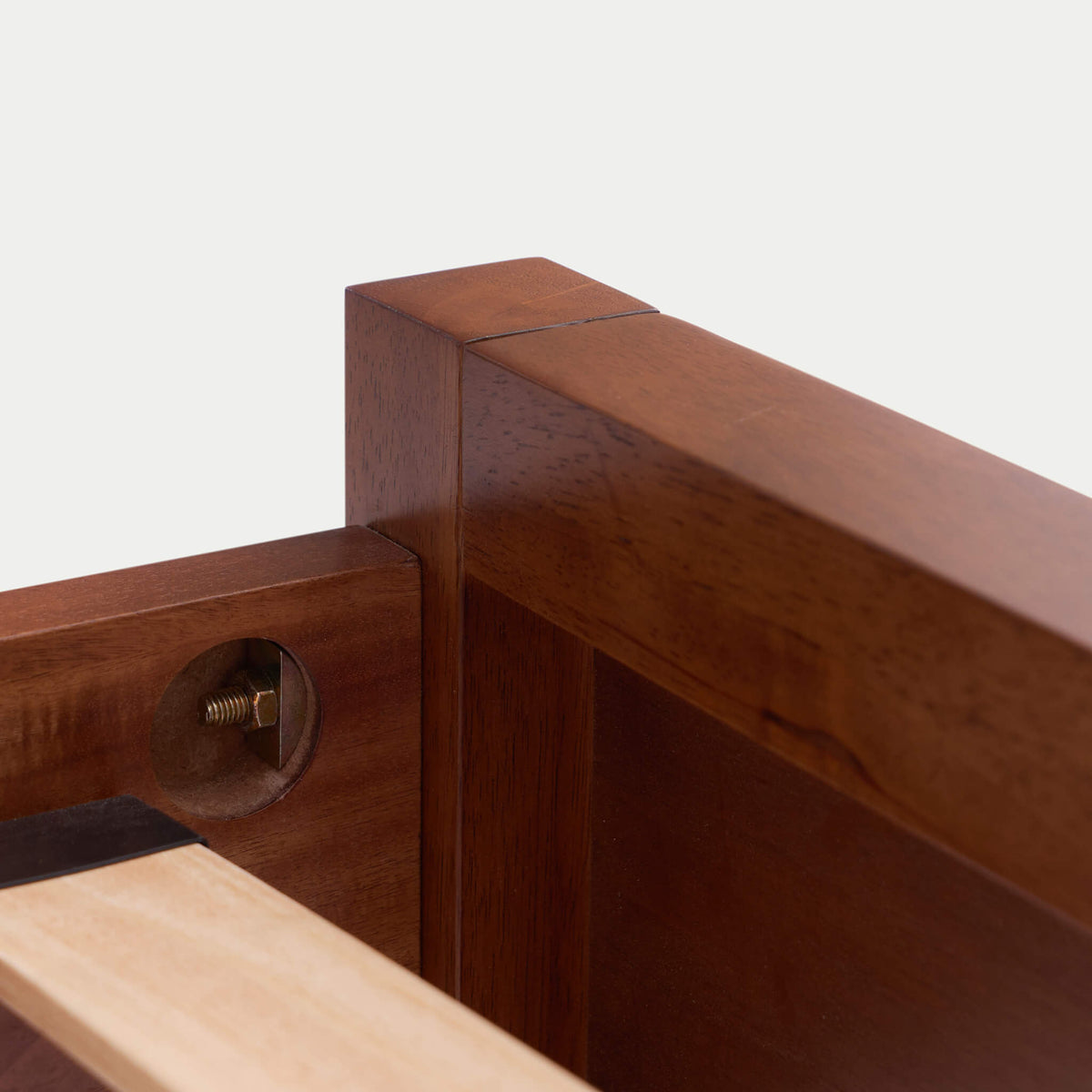 Close-up of a wooden furniture joint with a screw on a white background