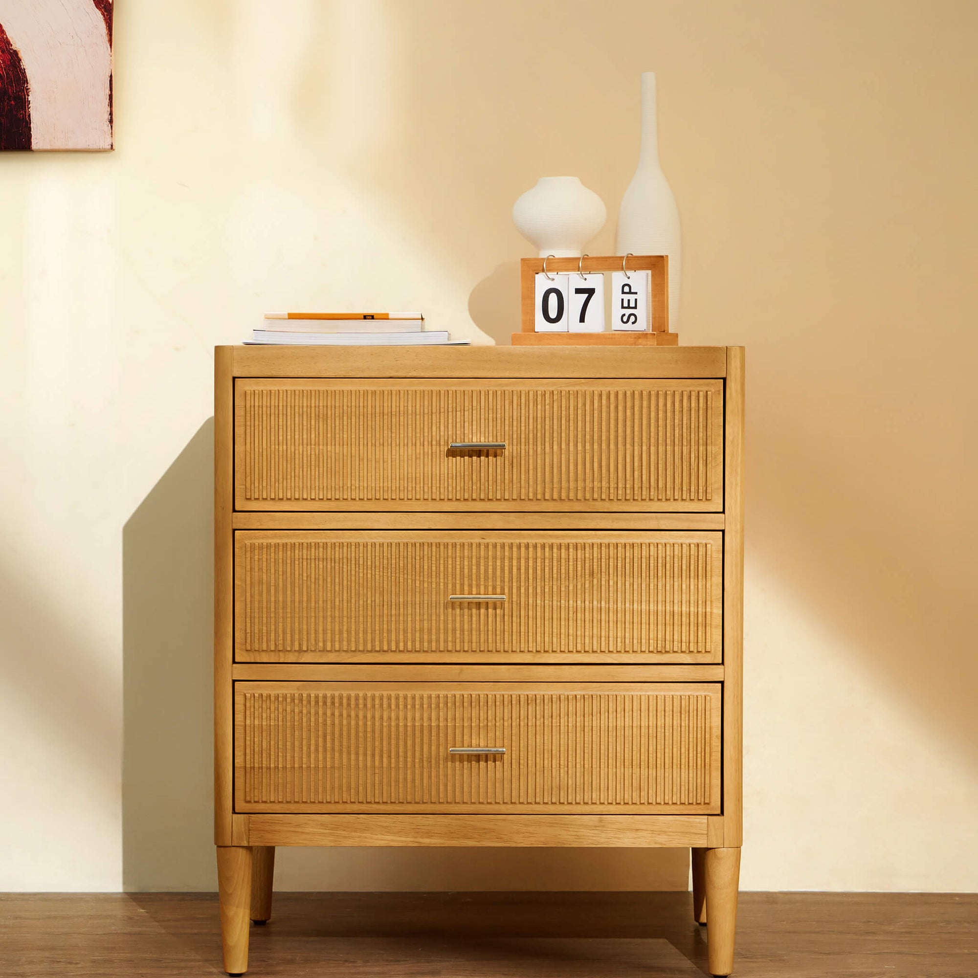 Arlo natural oak wide chest of drawers in a lifestyle setting with plants and home decor