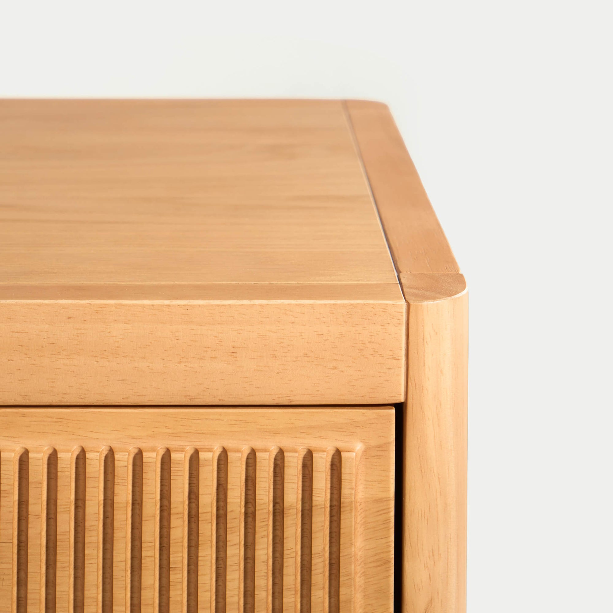 Close-up of Arlo natural oak chest fluted drawer front showing carved wood detail and stainless steel knob hardware