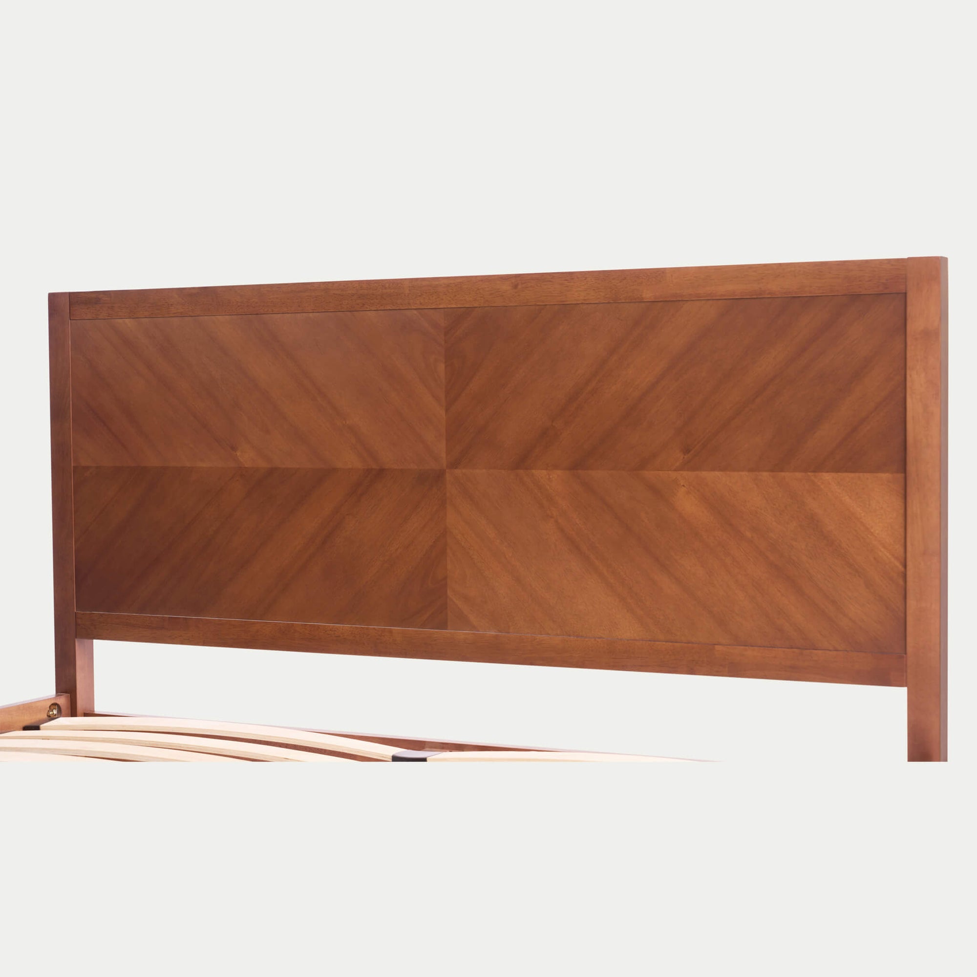 An intimate close-up of the KREVON Signature Series headboard, showcasing the handcrafted geometric herringbone wood inlay pattern of four distinct panels with natural acacia wood grain